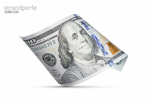 One hundred dollar bill floating down to surface with drop shadow isolated on a white background