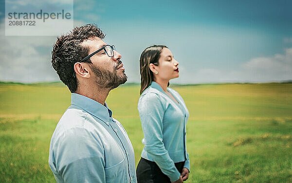 Young couple breathing fresh air in the field. Two relaxed people breathing fresh air in the countryside