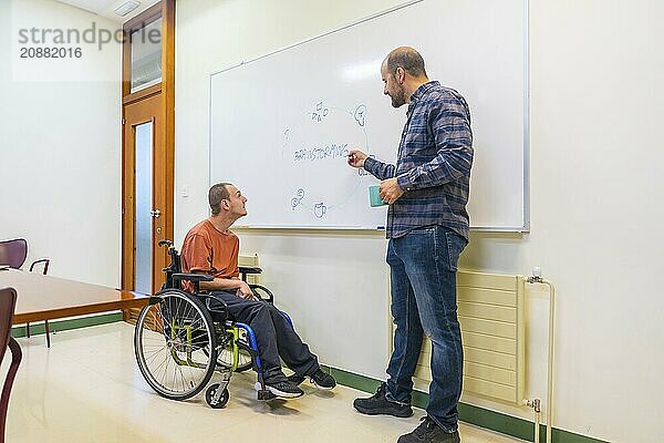 Man with cerebral palsy and colleague using board during brainstorming in a modern coworking