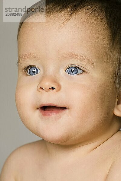 The blue-eyed baby  close up. gray background