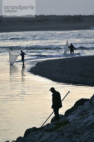 HOKITIKA  NEW ZEALAND  OCTOBER 24  2019: A man uses a scoop net at sunset for catching whitebait at the Hokitika River on the West Coast of the South Island