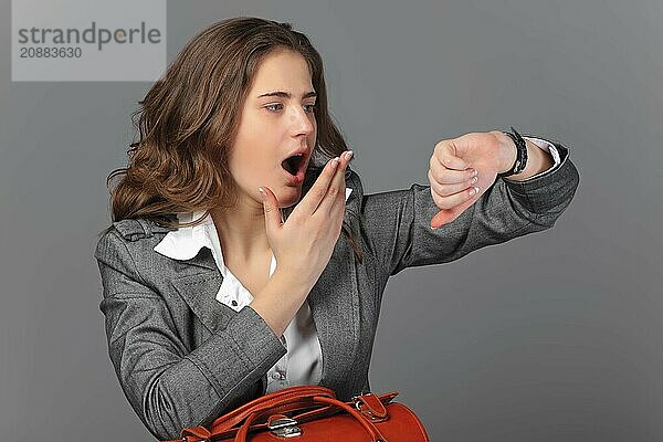 A businesswoman with a bag and a suitcase. On a gray background