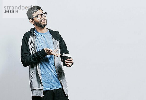 Smiling man showing coffee on isolated background. Guy pointing disposable cup of coffee isolated