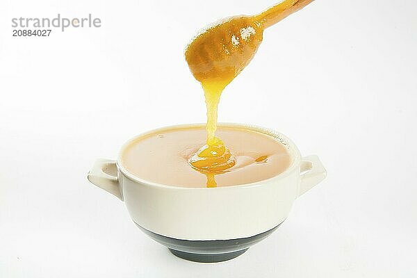 Juicy honey in a cup and spoon on white background