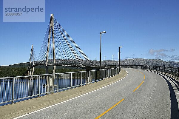 A modern bridge stretches across a wide expanse of water under a clear blue sky  Helgelandsbrua  Sandnesjoen  Kystriksveien  Rv 17  Nordland  Norway  Europe