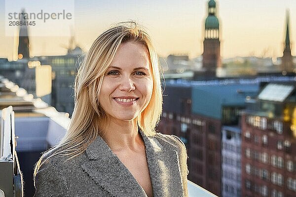 Blonde woman on a roof terrace smiling with a city view in the background  ai generated  KI generated  AI generated