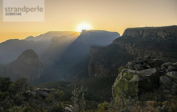 Light mood at sunrise at the Blyde River Canyon  sun rises behind a mountain peak  canyon landscape with sunbeams against the light  view of canyon with Three Rondawels peak and Table Mountains  Panorama Route  Mpumalanga  South Africa  Africa