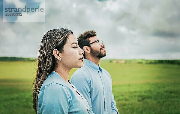 Young couple breathing fresh air in the field. Two relaxed people breathing fresh air in the field