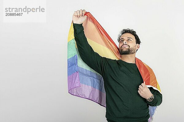 Studio shot of man holding LGBT rainbow flag