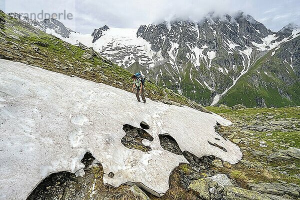 Mountaineer climbing over a snowfield to the Lapenscharte  Berliner Höhenweg  Zillertal Alps  Tyrol  Austria  Europe