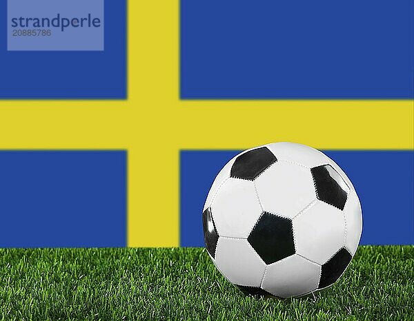 The Swedish flag and soccer ball on the green grass