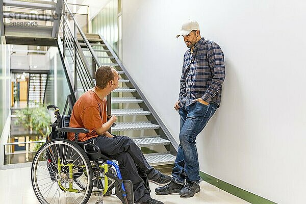 Man with disability talking with a colleague in a modern coworking during a work break