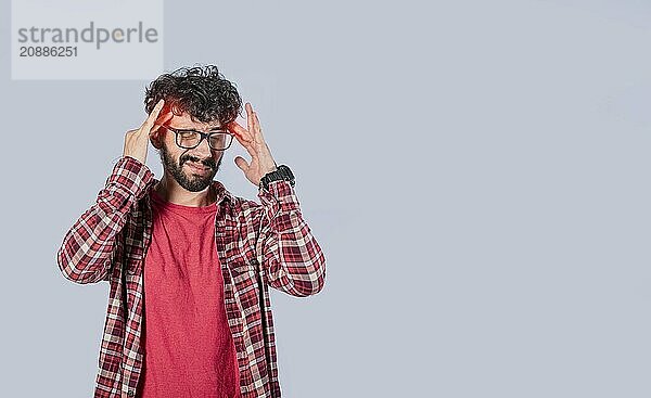 Man with a headache isolated. Young man rubbing head on isolated background