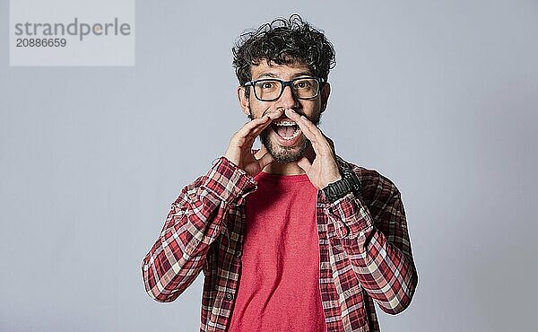 Cheerful man announcing with hands at camera isolated. Friendly young man announcing a promo isolated