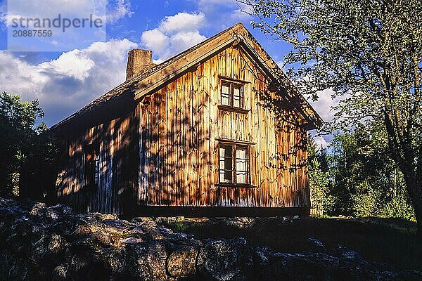 Old wooden cottage in sunlight on a summer evening  Sweden  Europe