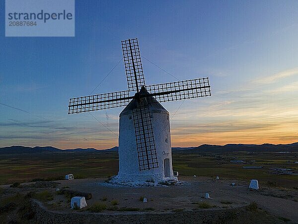 A windmill in a rural landscape at sunset with a calm atmosphere under a wide sky  aerial view  Consuegra  Toledo  Castilla-La Mancha  Spain  Europe