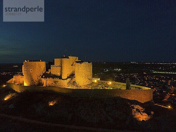 An illuminated castle at night with historical character and views of the city lights  aerial view  castle  Consuegra  Toledo  Castilla-La Mancha  Spain  Europe