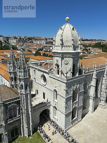 Large Gothic cathedral with high towers and a dome  surrounded by a cityscape under a blue sky  aerial view  Hieronymus Monastery  Mosteiro dos Jerónimos  Hieronymite Monastery  World Heritage Site  Monastery Church of Santa Maria  Belém  Belem  Bethlehem  Lisbon  Lisboa  Portugal  Europe