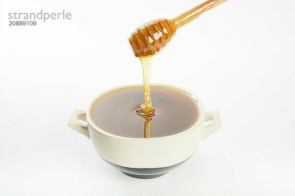 Juicy honey in a cup and spoon on white background