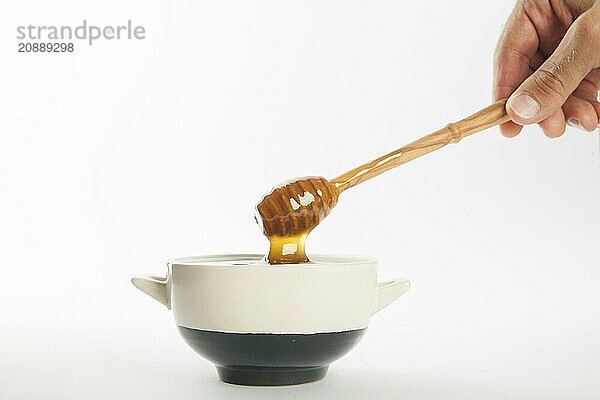 Juicy honey in a cup and spoon on white background