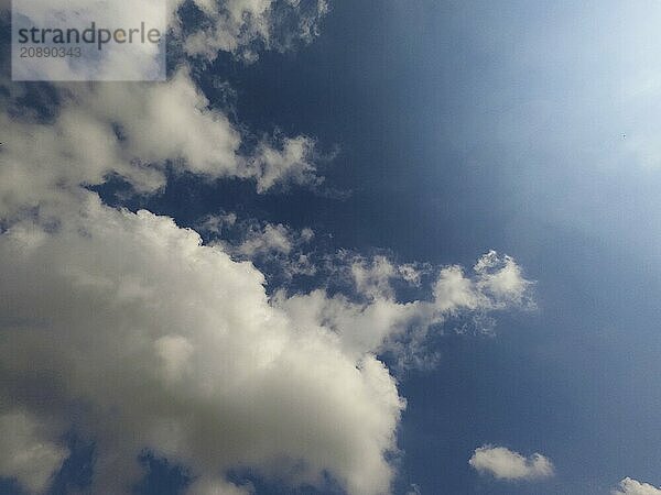 A partially cloudy sky with white clouds and a bright blue background under the sun  Scattered cloud clusters in a blue sky  blue sky background with white clouds