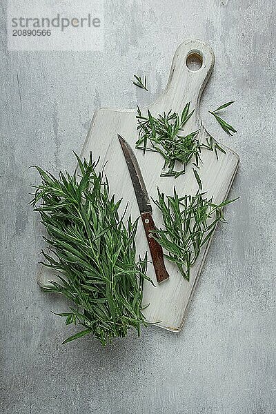 Fresh Tarragon  on a cutting board  slicing  on a light table  top view  no people