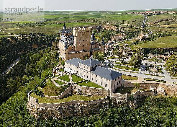 A medieval castle perched on a hill overlooking green meadows and a surrounding landscape  aerial view  Alcázar  Alcazar  Segovia  Castilla y León  Leon  Spain  Europe