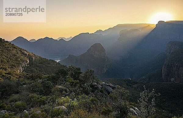 Light mood at sunrise at the Blyde River Canyon  sun rises behind a mountain peak  canyon landscape with sunbeams against the light  view of canyon with Three Rondawels peak and Table Mountains  Panorama Route  Mpumalanga  South Africa  Africa