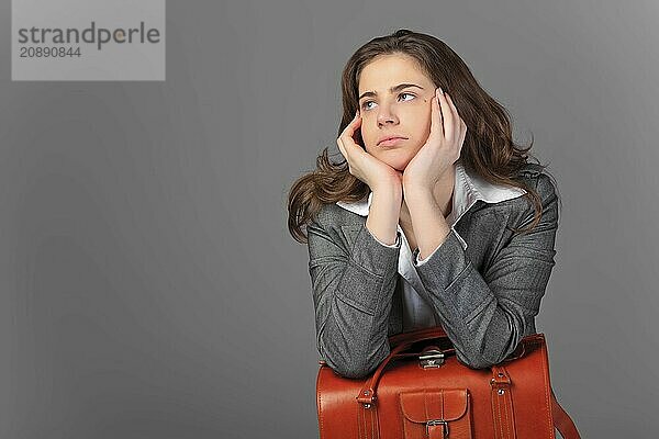 A businesswoman with a bag and a suitcase. On a gray background