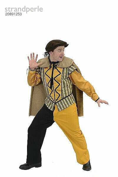 An actor in a court jesters costume poses before a white background