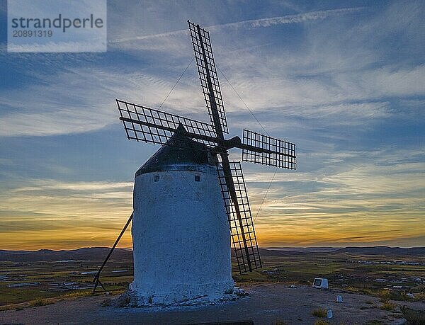 Single windmill against a dramatic sunset  silhouetted against a colourful sky  surrounded by a vast landscape  aerial view  Consuegra  Toledo  Castilla-La Mancha  Spain  Europe