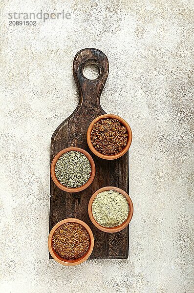 Georgian spices  in ceramic bowls  assortment  set of spices  utsho  adjika  Svan salt  ground coriander  top view  no people