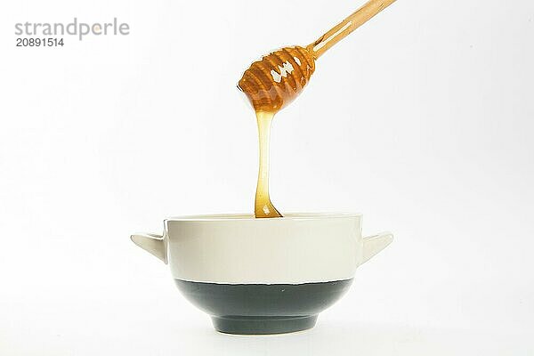 Juicy honey in a cup and spoon on white background