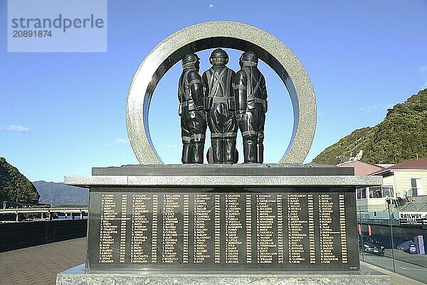 A memorial to coal miners lists the names of men killed in mining accidents in the Greymouth district since 1862. New Zealand  2022. The memorial stands on the Greymouth floodwall and depicts a mine portal with three miners dressed in work clothes