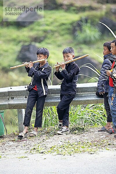 Vietnamese boys playing traditional flutes in the northern mountains  Ha Giang province  Vietnam  Asia