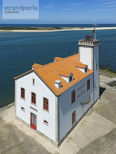 A lighthouse on the coast with a red roof and white façade  Museo Maritimo  surrounded by blue water and a clear sky  aerial view  Esposende  União das Freguesias de Esposende  Marinhas e Gandra  Portugal  Europe