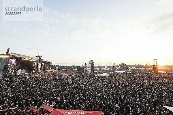 Overview of the crowd with the setting sun and the two main stages Faster and Harder at the Wacken Open Air in Wacken. The traditional metal festival takes place from 31 July to 3 August 2024