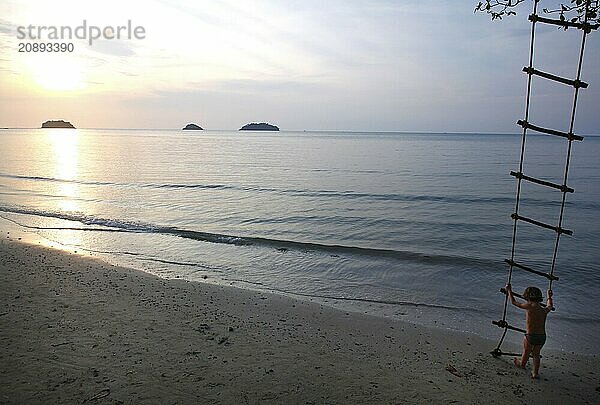 Cho Chang  Thailand  07.01.2010  Sunset at the beach  Cho Chang Island  Child on a rope ladder  Cho Chang  Thailand  Asia