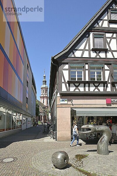 Sculpture snake by Franz Gutmann and view into the Pfarrstraße with the tower of the Heilig Kreuz church  snake figure  animal figure  apple figure  main street  Offenburg  Ortenau  Baden-Württemberg  Germany  Europe