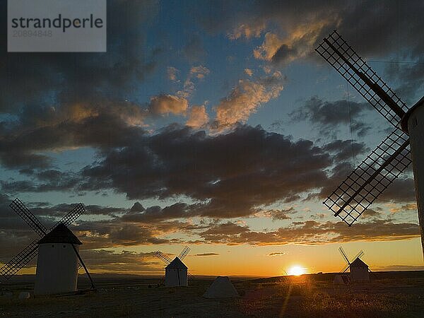 Several windmills in front of a dramatic sunset with colourful sky and clouds  creating a calm and peaceful atmosphere  aerial view  windmills  Campo de Criptana  Ciudad Real province  Castilla-La Mancha  Route of Don Quixote  Spain  Europe