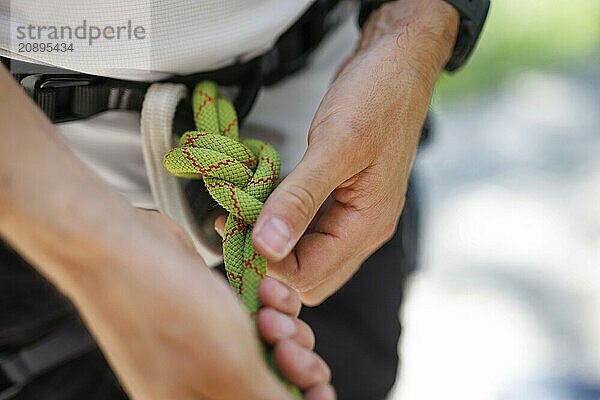 A climber ties himself into a rope to climb on the rock  Morsbach  09.07.2024