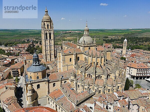 Aerial view of a historic city with a large church and red roofs under a clear blue sky  surrounded by a wide green area  aerial view  Cathedral  Alcázar left  Alcazar  Segovia  Castilla y León  Leon  Spain  Europe