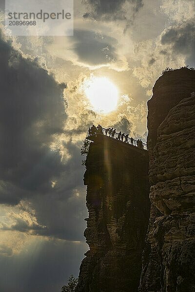 The Bastei is a rock formation with a viewing platform in Saxon Switzerland on the right bank of the River Elbe in the municipality of Lohmen between the spa town of Rathen and the town of Wehlen. It is one of the most visited tourist attractions in Saxon Switzerland. Dramatic sky over the Bastei. ourists on the new viewing platform  Saxon Switzerland  Rathen  Saxony  Germany  Europe