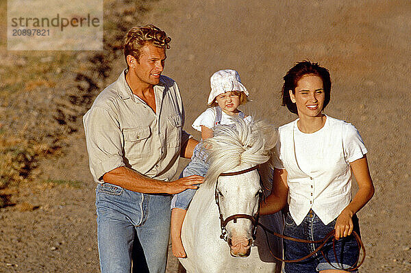 Family outdoors. Child's pony ride.