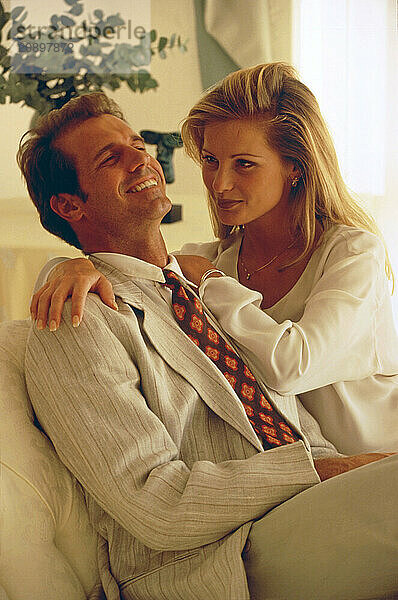 Young couple sitting together indoors.