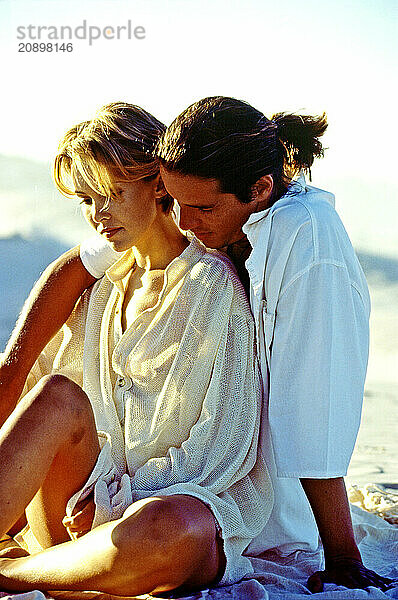 Young couple sitting on a beach.