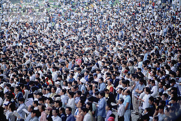 Japan. Spectators crowd on terraces at outdoor sporting event.