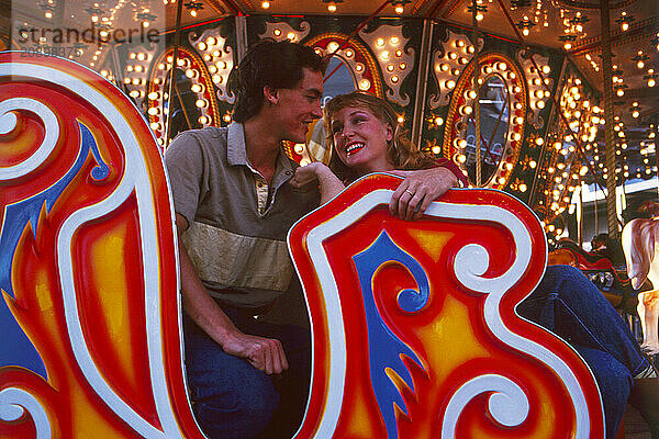 Young couple on ride at funfair. Luna Park Sydney.