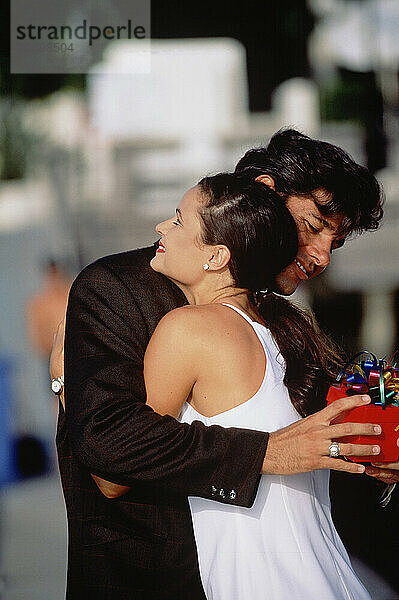 Close up of young couple embracing outdoors.