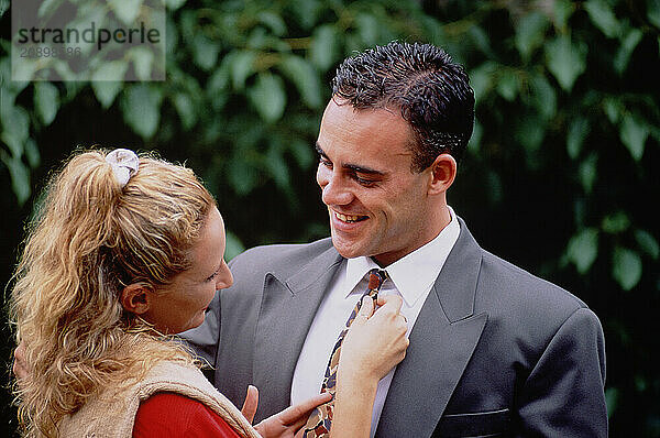 Outdoor portrait of young couple in garden.